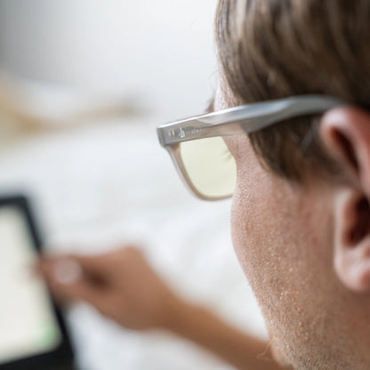 Person wearing Signature Blue Light Glasses using a laptop with a blurred background