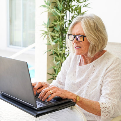 Woman using a laptop in a bright room with plants
