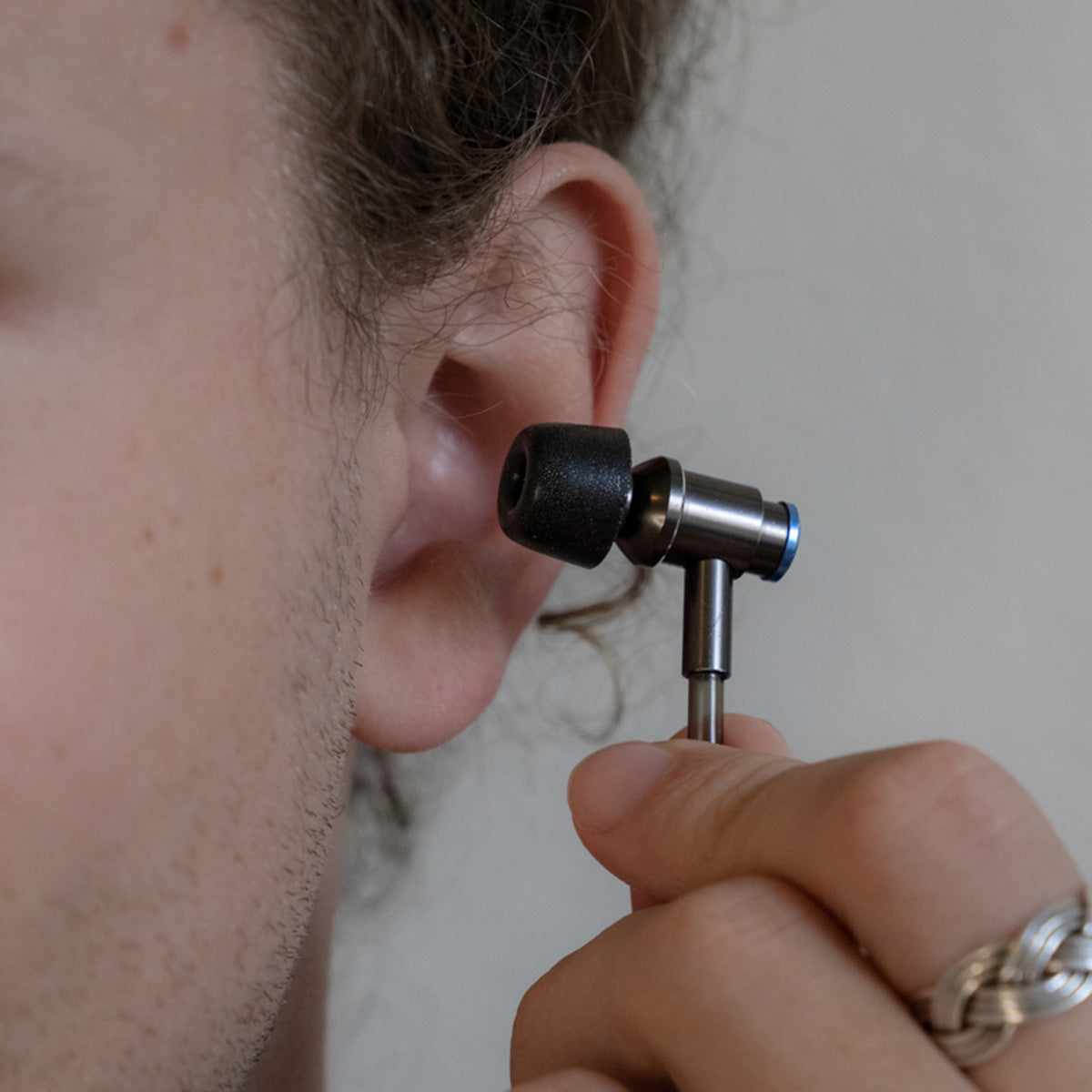 DefenderShield EMF Protection Memory Foam Ear Tips Man Putting Earbuds Into Ear