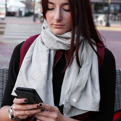 DefenderShield EMF Protection Gray Scarf woman sitting outside holding phone