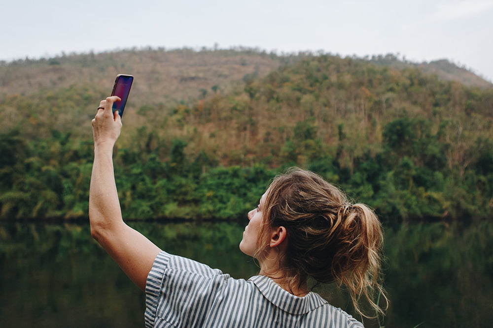 Digital Wellness Woman Holding Smartphone in Nature for Signal